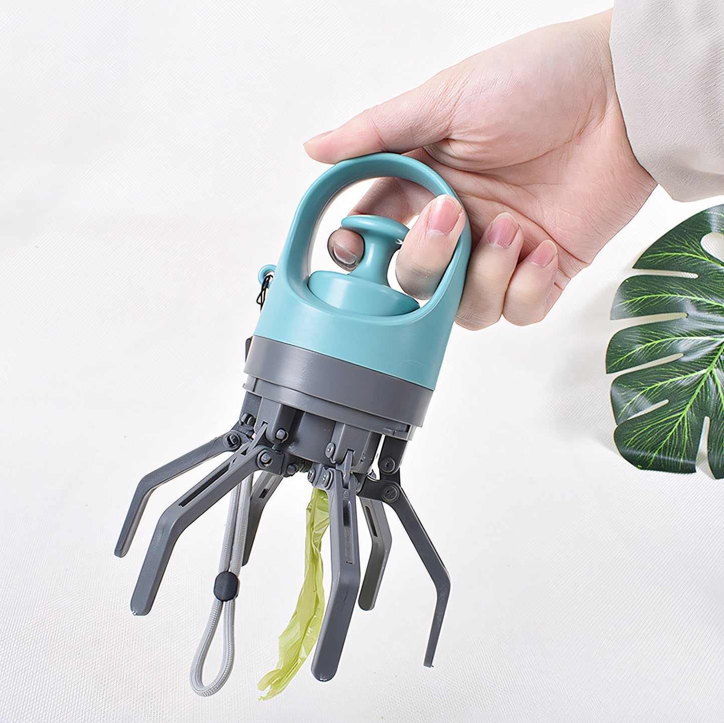 Hand holding a blue and gray tool with plant material on a white background